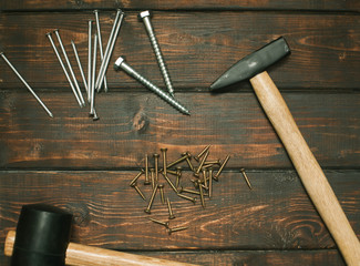 Hammer, construction and repair tools on wooden board background, top view, closeup