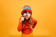 © Drobot Dean - Joyful Young girl in sweater and hat looking at camera