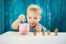 Three Years Old Child Sitting St The Table With Money And A Piggybank