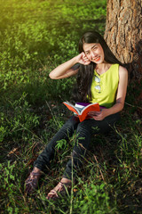 Sticker - woman sitting and holding a book in the park