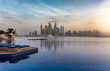 Die Skyline der Dubai Marina bei Sonnenuntergang mit Reflektionen in einem Swimming Pool