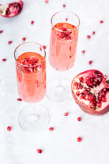 Two glasses of pink champagne. Rose sparkling with pomegranate on white marbel background