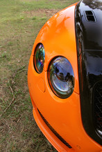 Part Orange Car On Asphalt Background. Tuning. Orange Luxury Car