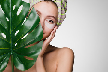 happy woman with a towel on her head struck patches under the eyes