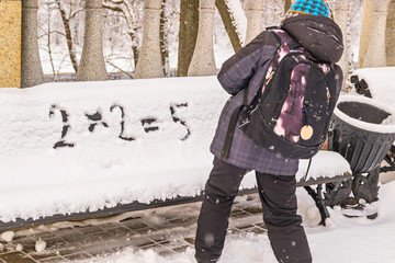 Wall Mural - Naughty boy wrongly decides an example on a snow-covered bench