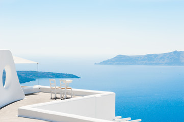  Dwa krzesła na tarasie z widokiem na morze. Wyspa Santorini, Grecja. Tło podróży i wakacji