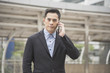 © NaMong Productions - Handsome businessman asian talking on mobile phone.