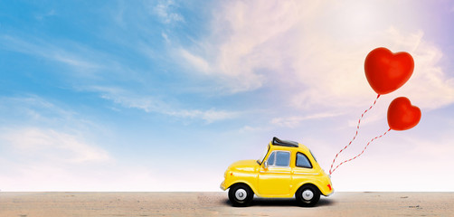 Miniature car with two red heart balloon. concept of love  wedding honeymoon