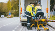 Sanitäter schieben Frau in Rettungswagen auf Transportliege 