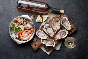 Wall Mural - Fresh seafood and white wine on stone table