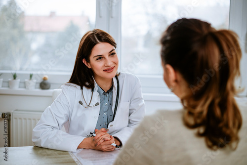 Fotografía Cheerful young doctor listening to a patient in the office.
