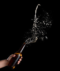 Sticker - Gold beer bottle opening with exploding and splashing on dark background