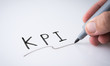 © showcake - Hand holding black permanent marker and writing word 'KPI'on white background