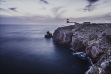 Beautiful Atlantic Ocean View Horizon With Lighthouse , Flowers And Rocks  At Sunset. Algarve,  Portugal. Vintage Toned Picture