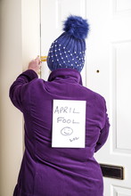 April Fool Sign.
A Lady Leaving Home And Going Out With An April Fool Sign On Her Back,
