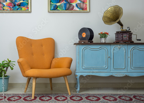 Dekoracja na wymiar  zabytkowe-wnetrze-retro-pomaranczowy-fotel-vintage-drewniany-jasnoniebieski-kredens-stary-gramofon