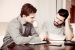 © JackF - Two troubled men reading documents at desk