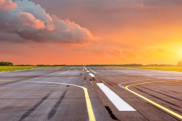 Wall Mural - Runway at the airport the horizon at sunset in the center of the sun.