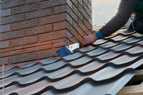 Cuadros en Lienzo Roofer builder worker attach metal sheet to the chimney