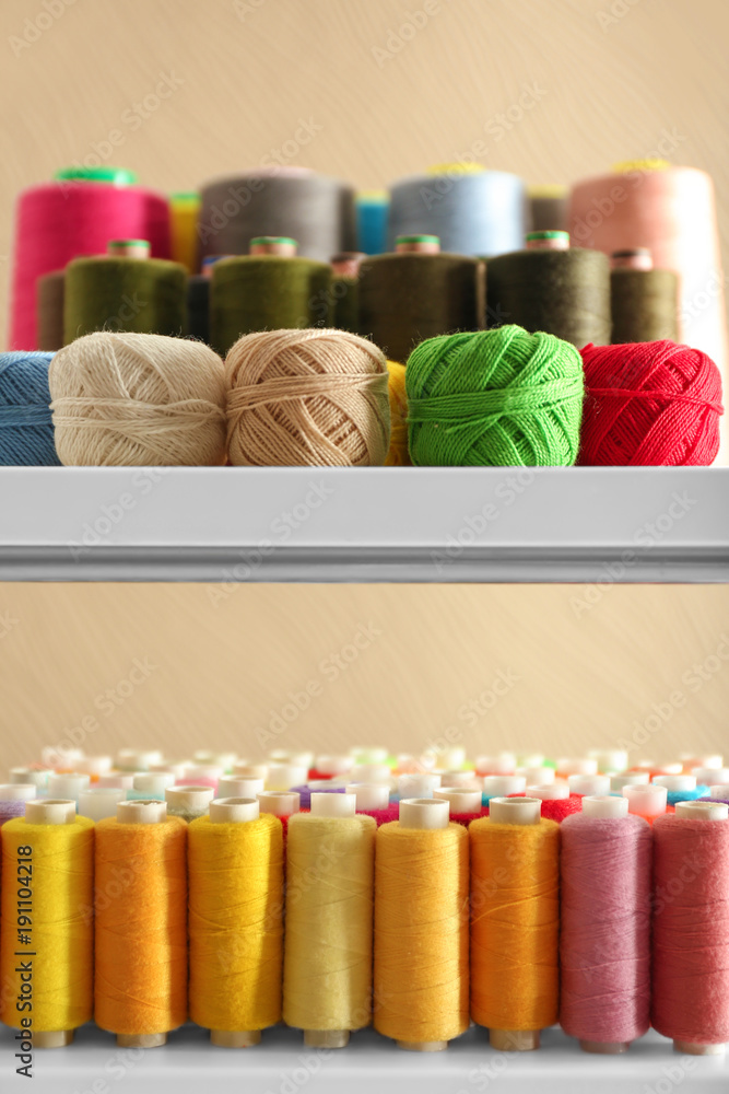 Set of color sewing threads and crocheting clews on shelves