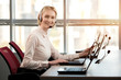 © DenisProduction.com - Female operator with headset smiling. Adult female secretary with headphones doing customer service in a callcenter.