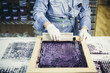 © Cavan Images - Midsection of craftswoman using silk screen to print design on fabric at workshop