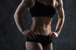 © romankosolapov - Sports sexy girl with big muscle belly in a black sportswear on a black background. A six-pack on his stomach in black color. Taut, pumped up, firm abdomen
