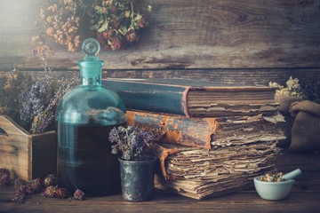 Wall Mural - Tincture bottles, assortment of dry healthy herbs, old books, mortar, curative drugs. Herbal medicine. Retro styled.