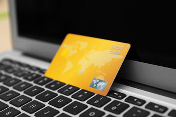 credit card on laptop keyboard, closeup. internet shopping concept