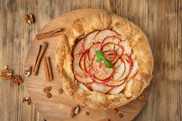 Poster - Wooden board with freshly cooked apple tart on table, top view