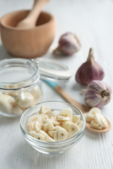 Canvas Print - Bowl with chopped garlic and cloves in jar on wooden table