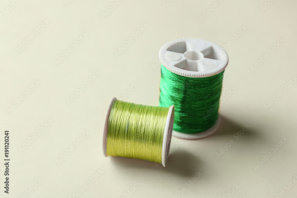 Green sewing threads on light background