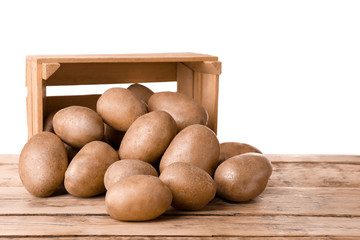 Sticker - Overturned wooden container with fresh raw potatoes on table against white background