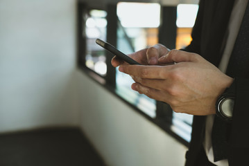 businessman holding smartphone & using app at office. man texting message at workplace. social network communication, wireless connection, lifestyle concept
