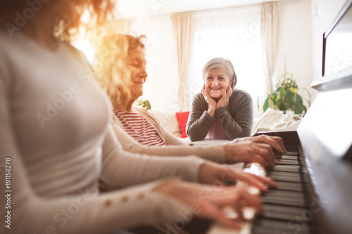 Pinturas sobre lienzo  A girl with mother and grandmother playing the piano.