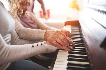 Wall Mural - A girl with grandmother playing the piano.