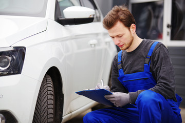 Mechaniker bei der Durchsicht eines Autos, TÜV-Untersuchung 