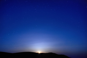Wall Mural - Blue dark night sky with many stars. Moon rising. Space background