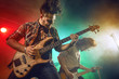 © Voloshyn Roman - Rock band performs on stage. Guitarist, bass guitar and drums.