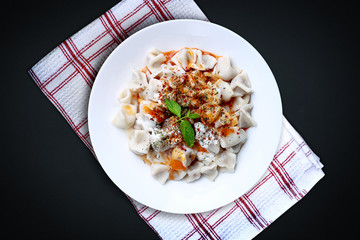 Plates of traditional Turkish food. Manti(Turkish ravioli) with tomato sauce.