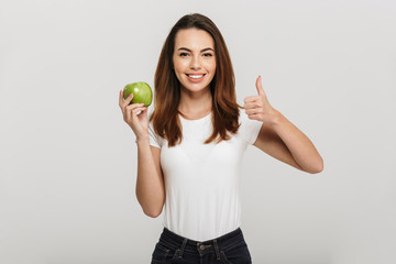 Wall Mural - Portrait of a healthy young woman holding green apple