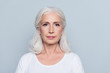© deagreez - Portrait  of nice, charming, aged, concentrated, woman with serious expression, standing over gray background