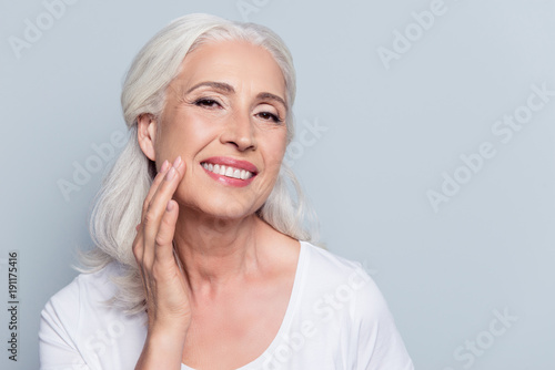 Fotomural Charming, pretty, old woman touching her perfect soft face skin with fingers, sm