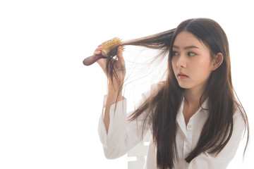 Portrait  of asian woman long hair with a comb and problem hair on white background. This image for hair loss concept. Free from copy space.