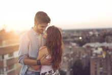 Couple In Love On A Building Rooftop At Sunset