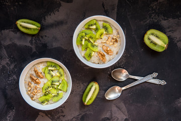 Oatmeal porridge with kiwi fruit and walnuts top view