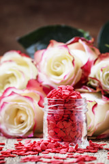 Wall Mural - Red sweet heart in glass jar, Valentines Day composition, fresh pink and white roses, vintage wooden background, selective focus