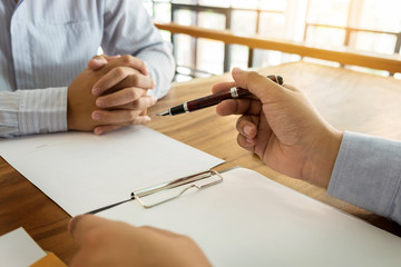 Wall Mural - Close-up Of Businessperson Signing Contract,woman writing paper at the desk with pen and reading books at table with basic Form document working in office