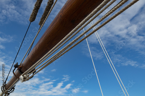 Fotografie, Obraz Sailboat Mast and ropes with cloudy blue sky in the background