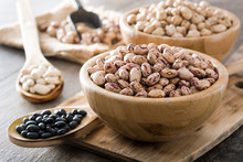 Uncooked Assorted Legumes In Wooden Bowl On Wooden Table